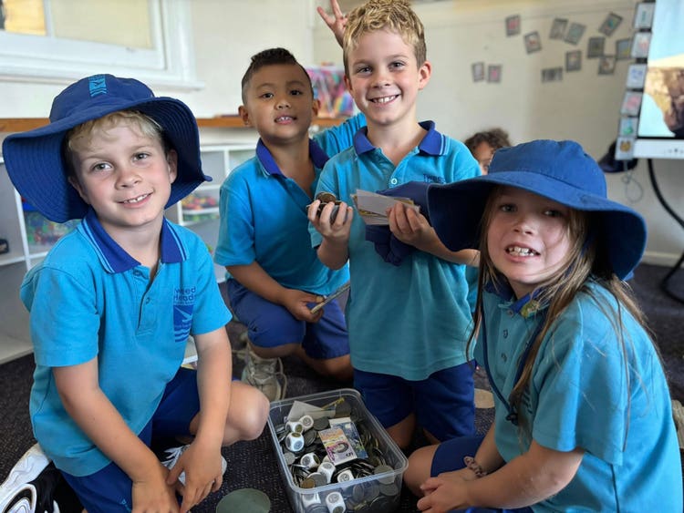 a group of students learning about money in the classroom