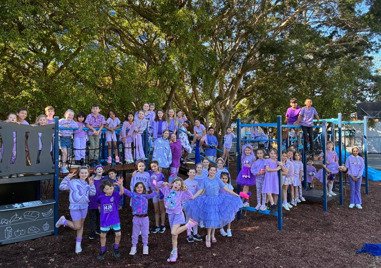 A large group of students dressed in casual purple clothes to support