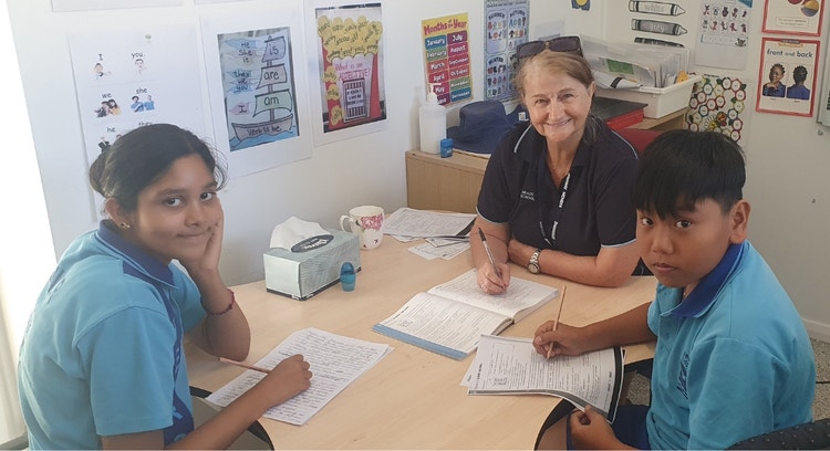Our EAL/D teacher at a small table supporting two students with their writing