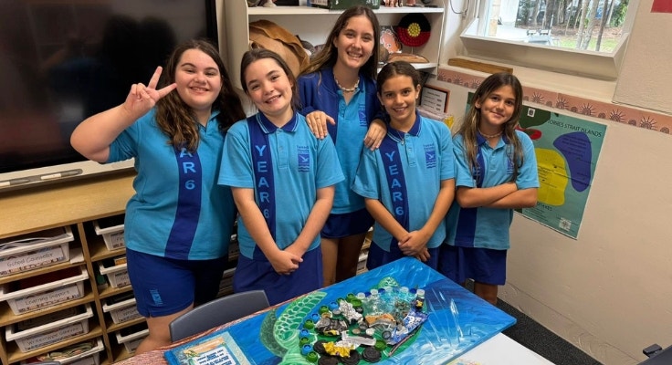 students with an artwork of a turtle made from collected rubbish