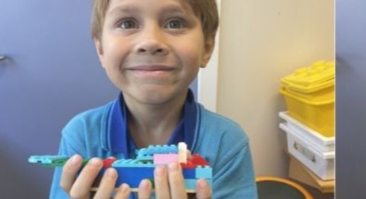 Students showing off his design from Lego Club